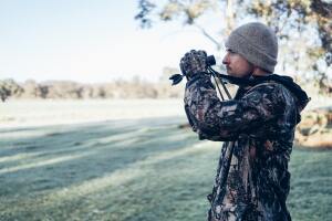 man in camo with binoculars - hunting leases are one way that landowners can make money from their land