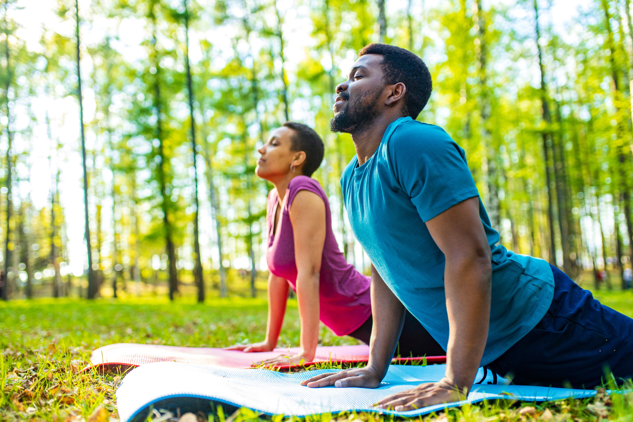 african-american couple doing yoga in the forest