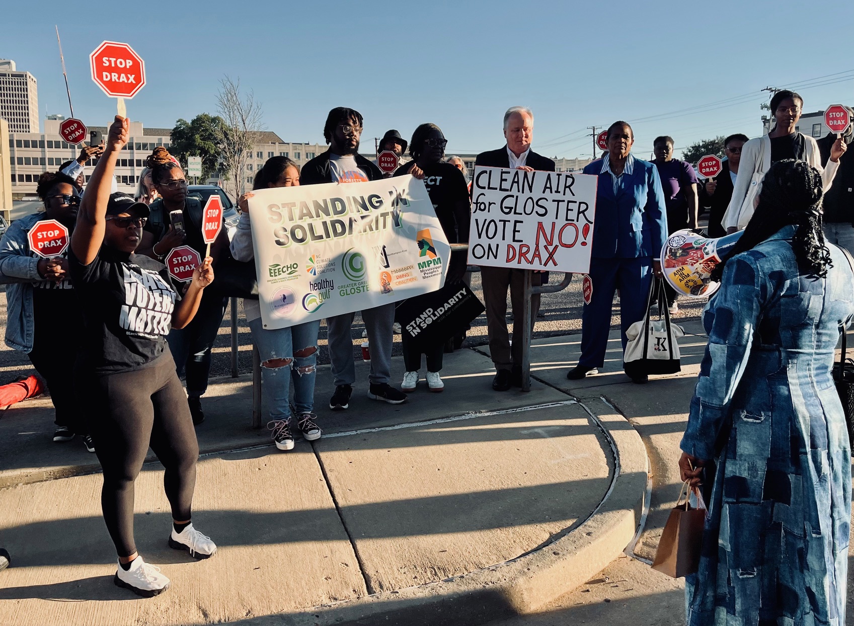 protestors with signs to protect MS air quality against Drax wood pellet plant