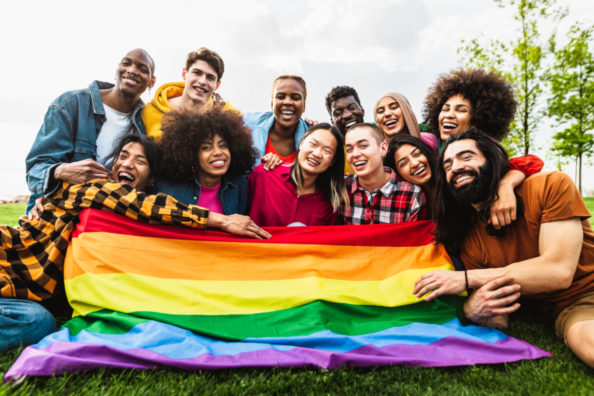 group-of-laughing-people-over-LGBTQ+-flag