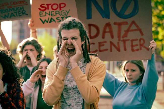 Youth activists protesting against data centers with signs about water waste and energy consumption