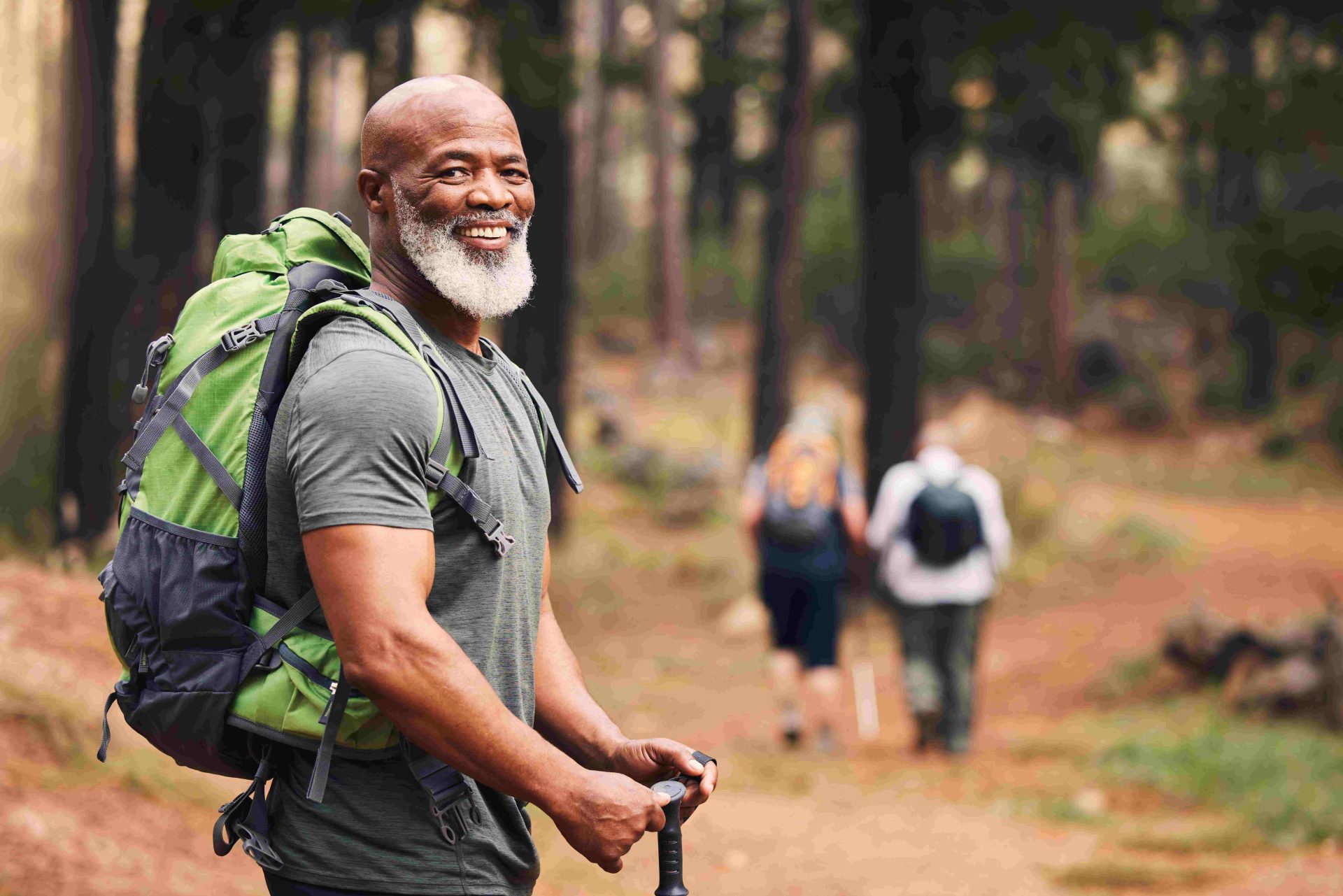 senior elder man with backpack hiking in woods